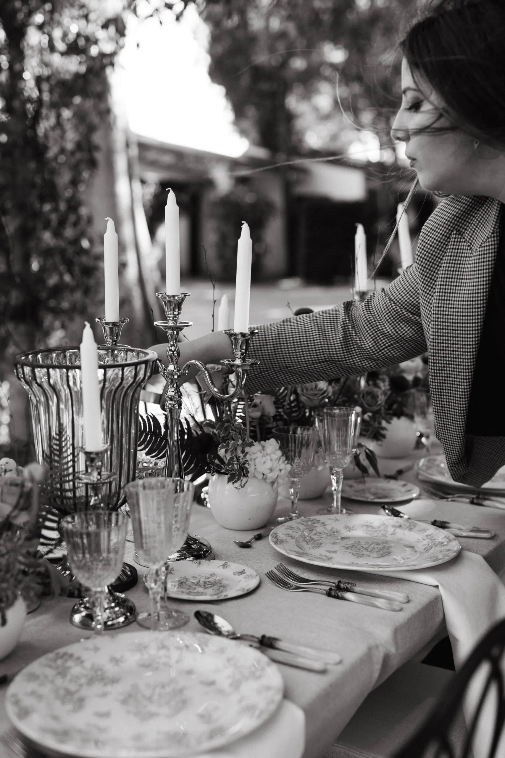Wedding planner de Bouclé Weddings decora mesa de bodas y coloca una vela en un candelabro.