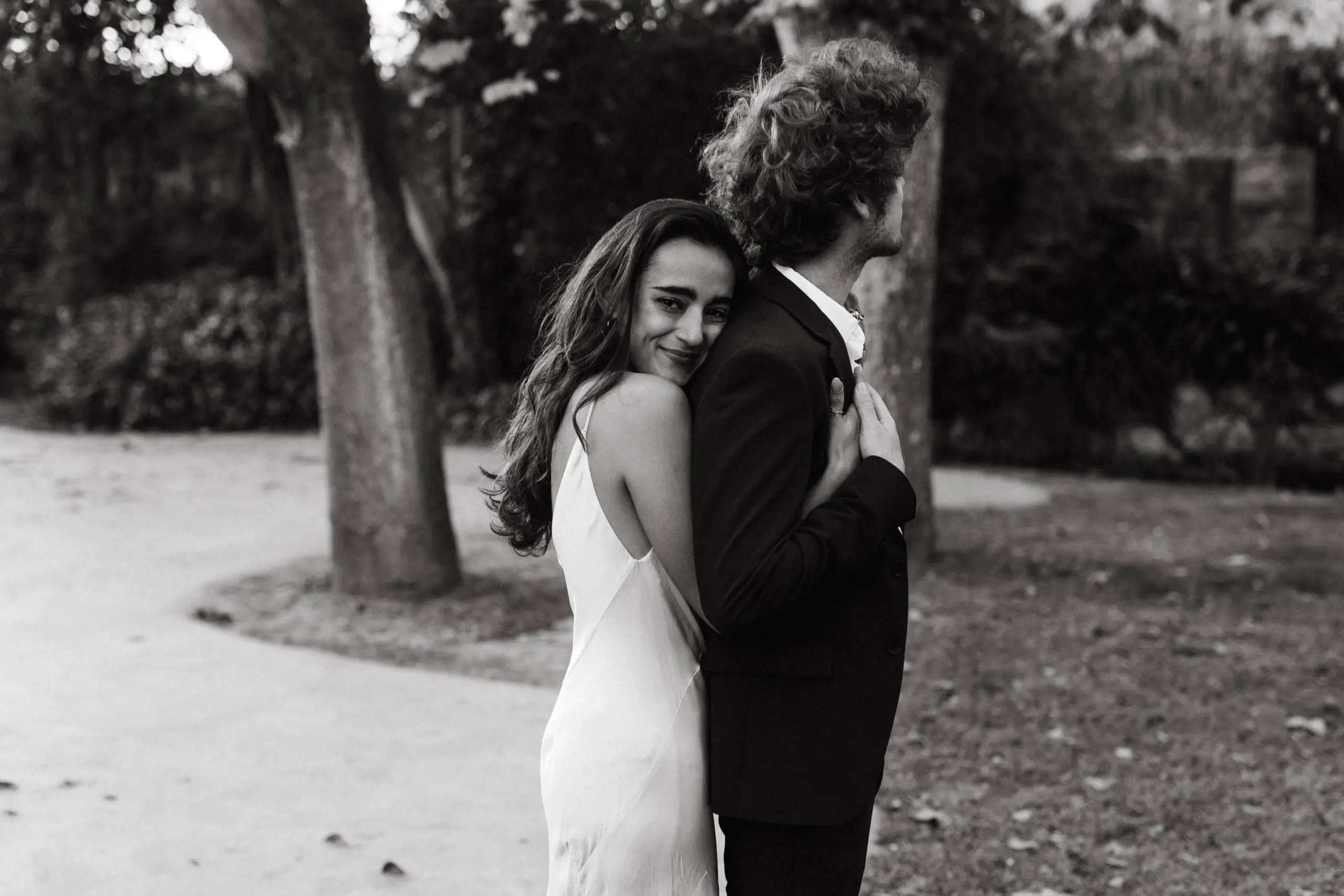 Fotografía en blanco y negro de novios abrazándose felices en un entorno natural en Casa Santonja, capturando un momento de pura alegría.
