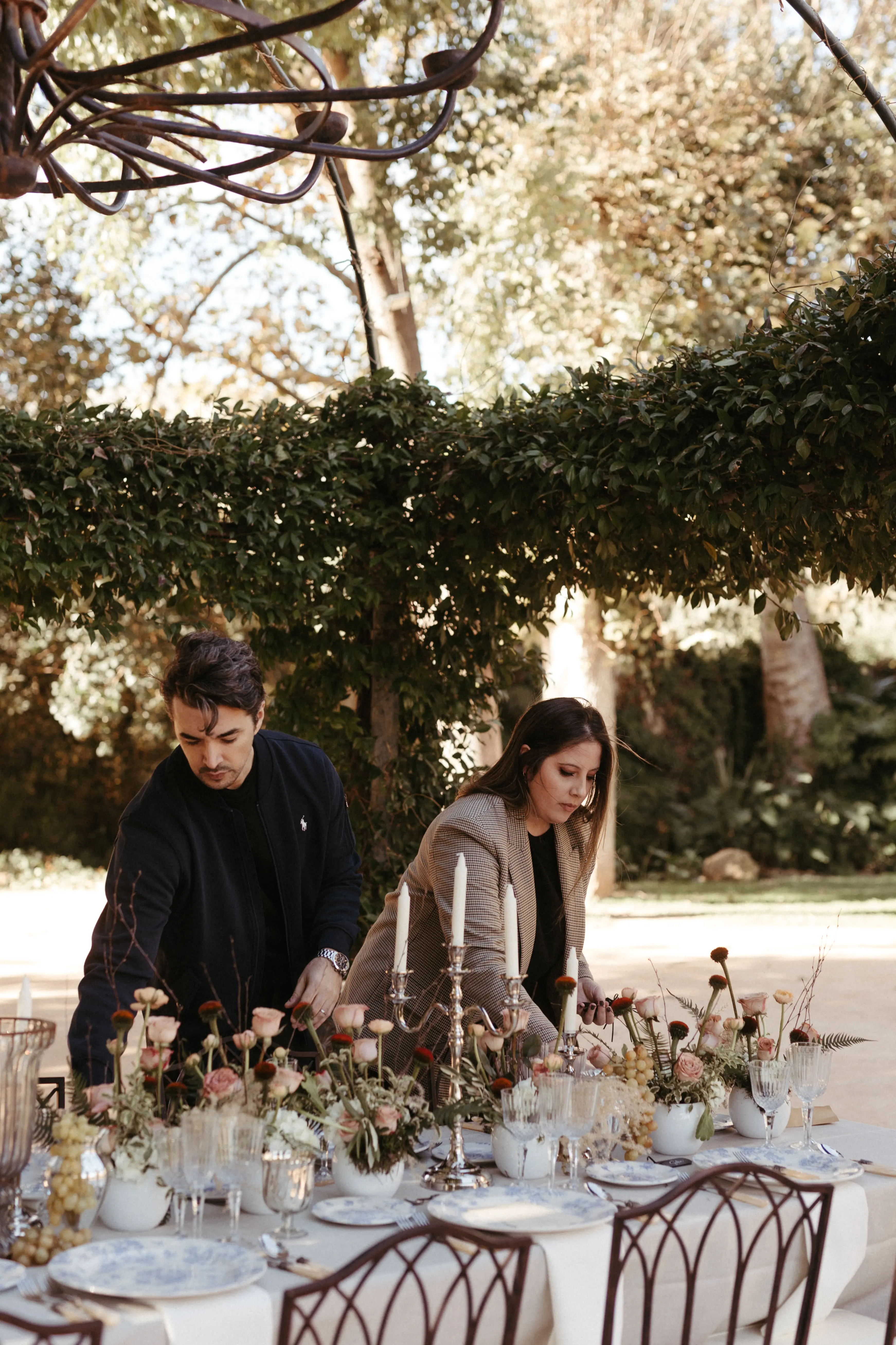 Bouclé Weddings' wedding planners arranging a wedding table in a natural setting.