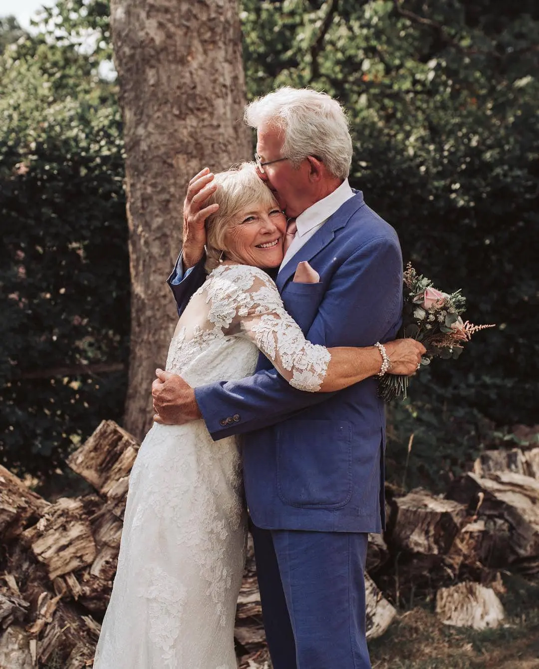 A mature couple at their wedding sharing a kiss and smiles.
