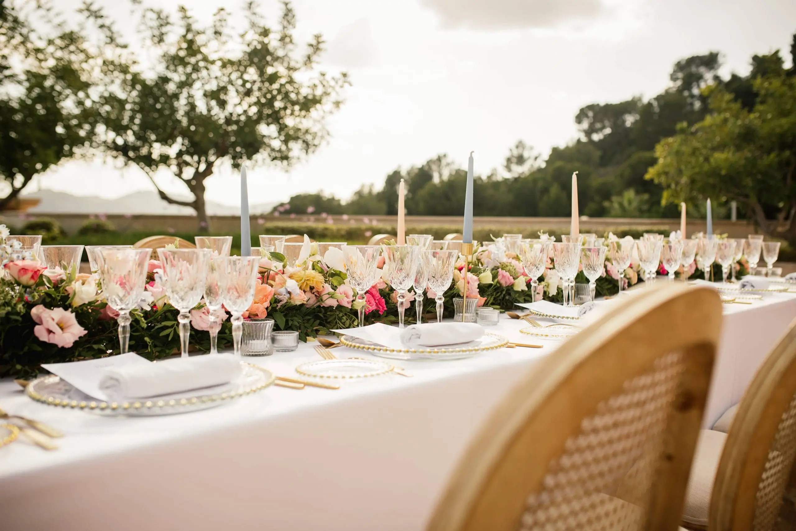 Mesa imperial decorada por Bouclé Weddings con flores coloridas, cubertería dorada y cristalería brocada, ambientada en Mallorca.