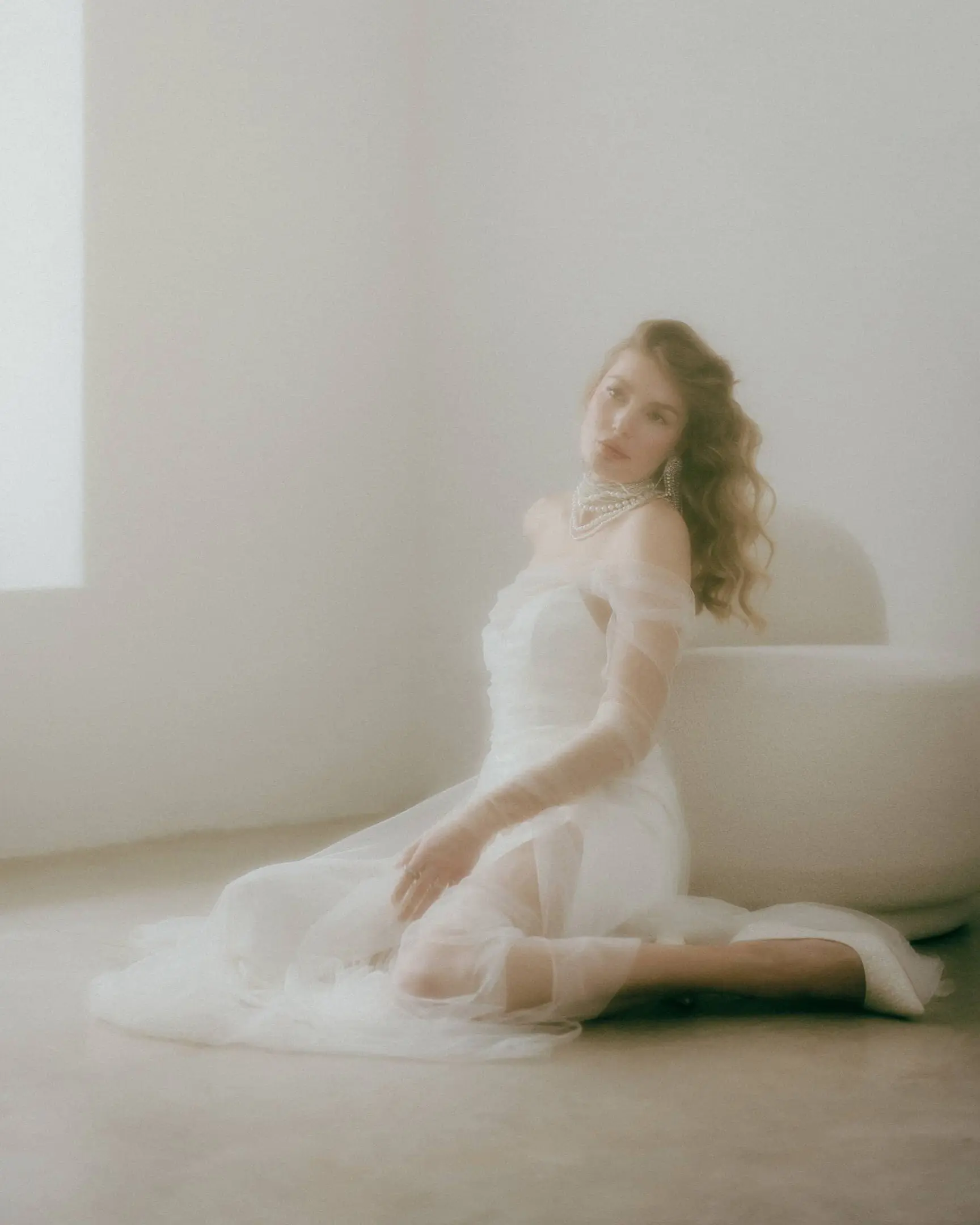 Fotografía difuminada de una novia sentada en el suelo.