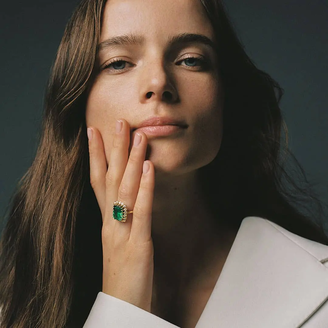 Mujer llevando un anillo de compromiso de esmeralda de Suárez.