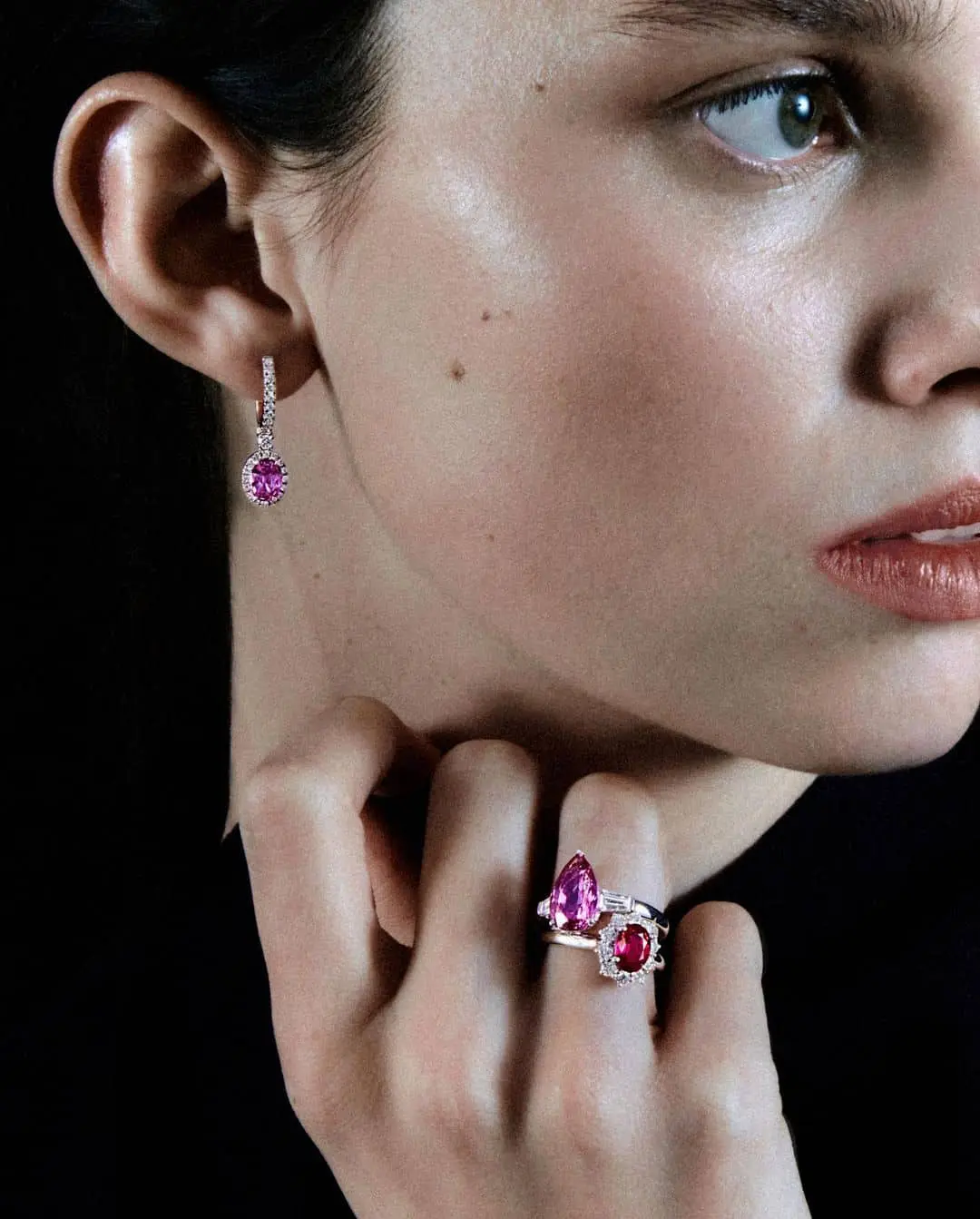 Mujer con labios pintados de rojo y anillo de compromiso de Suárez con rubíes y pendientes a juego, última tendencía de anillos de compromiso para 2025