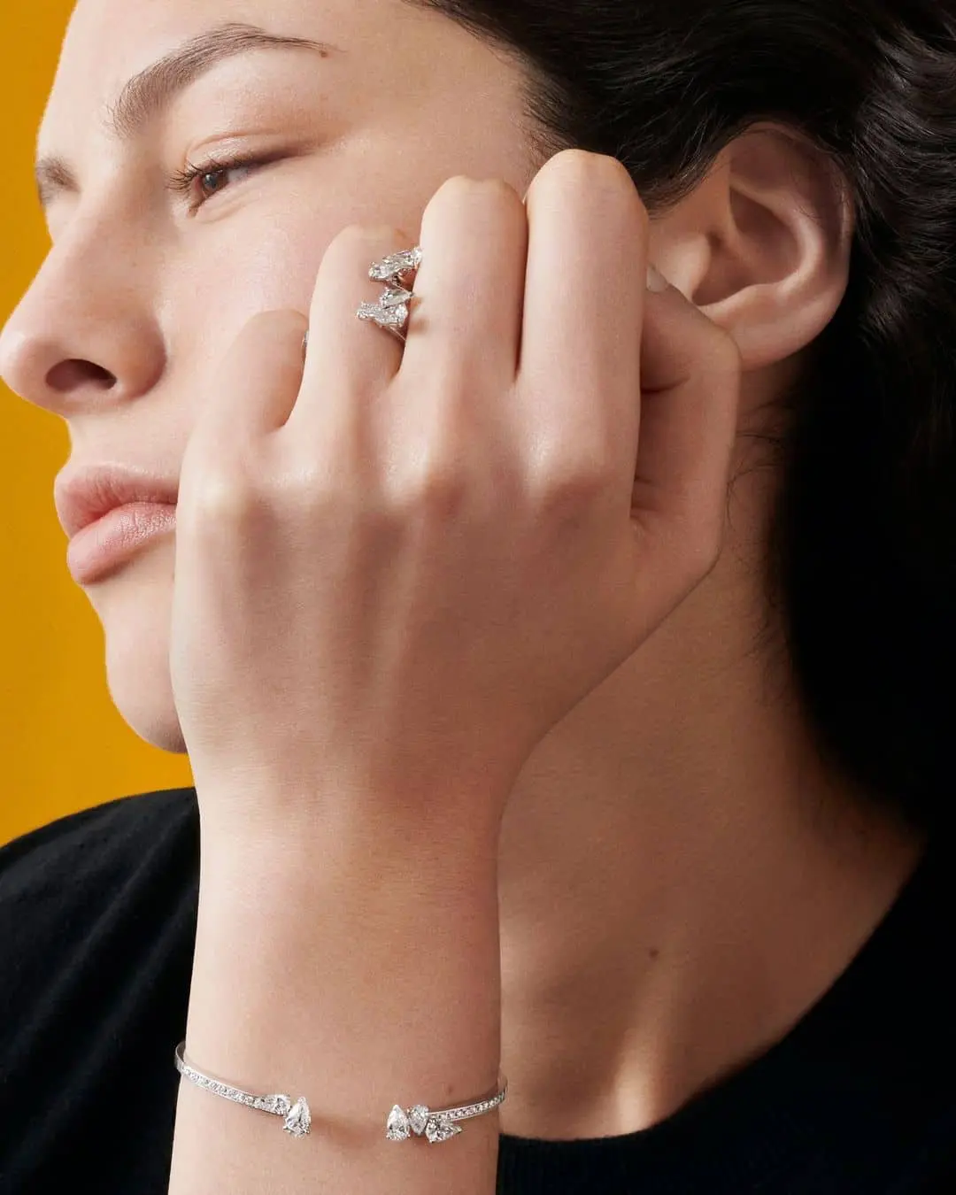 Mujer con anillo de compromiso abierto de Repossi y brazalete a juego