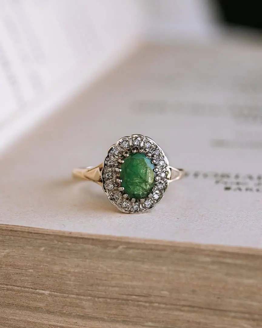 Anillo de compromiso vintage de Urbieta Antique sobre un libro antiguo