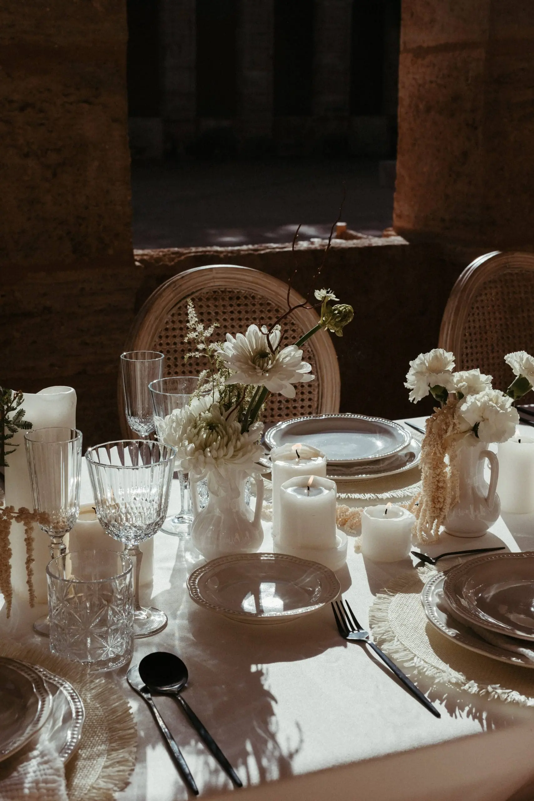Jarrones de cerámica y velas en mesa de boda en Cartuja de Ara Christi.