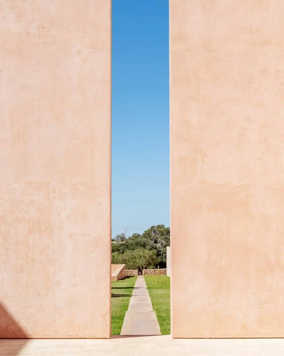 Encantadora vista a través de una rendija entre paredes en los jardines de Neuendorf House. Esta es una de las mejores fincas para bodas en Mallorca.