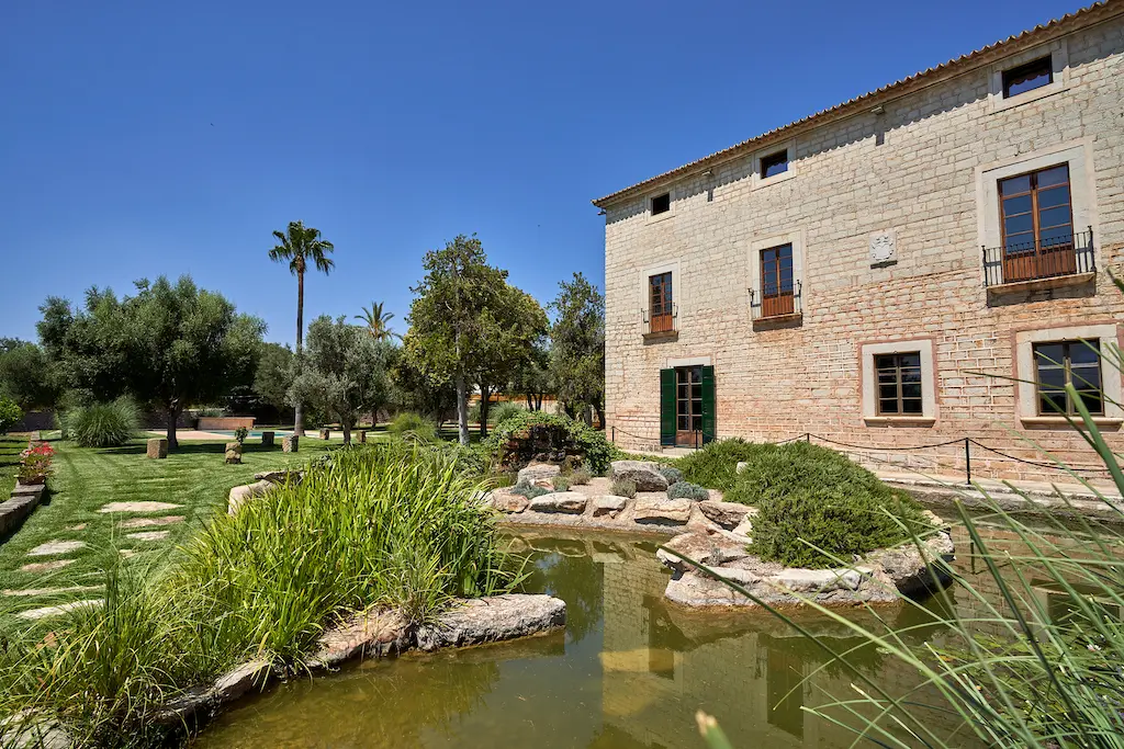 Vista frontal de la fachada de Finca Morneta con su impresionante lago