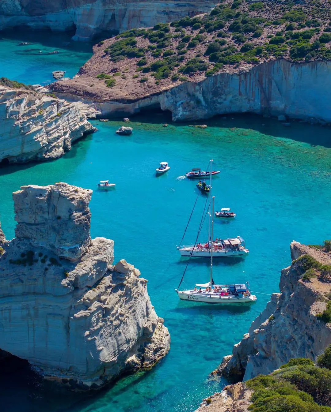 Veleros y yates en aguas cristalinas de una isla del Dodecaneso, destino de luna de miel de lujo