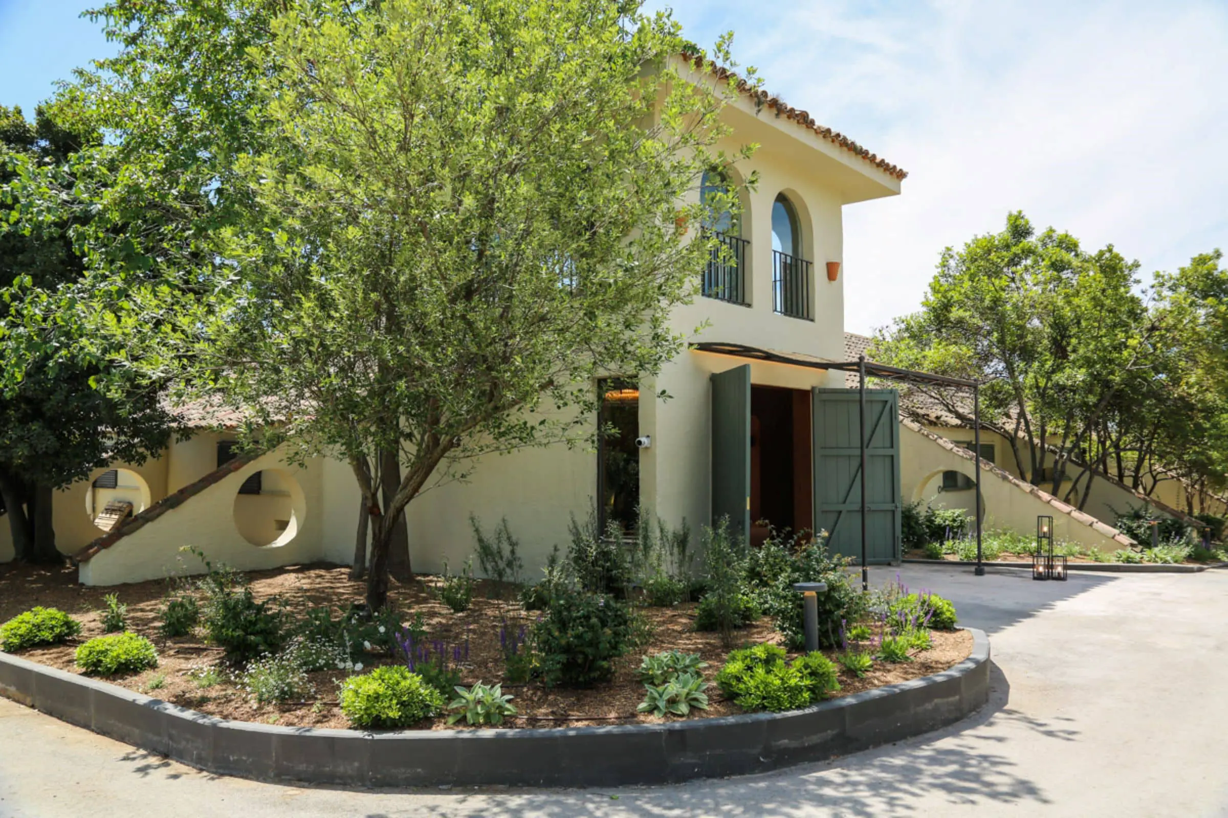 Fachada exterior del Cortijo de Mónico, rodeada de exuberante vegetación, uno de los mejores lugares para bodas en Madrid.