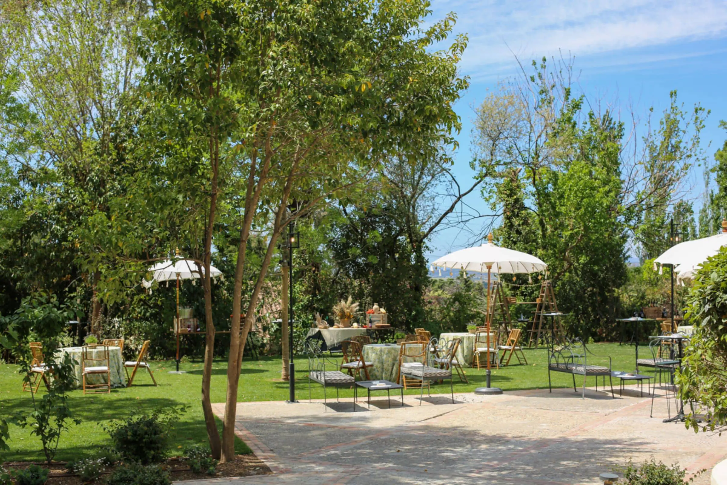 Jardín exterior del Cortijo de Mónico con una elegante mesa de cóctel preparada para la recepción de boda, un espacio exclusivo en una de las mejores fincas para bodas en Madrid.