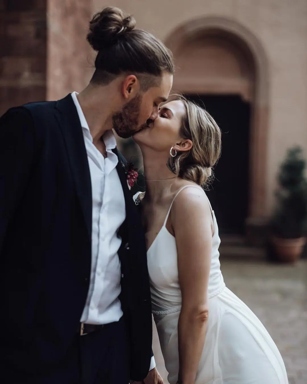 Novios compartiendo un beso alegre y genuino después de intercambiar votos matrimoniales llenos de originalidad y humor