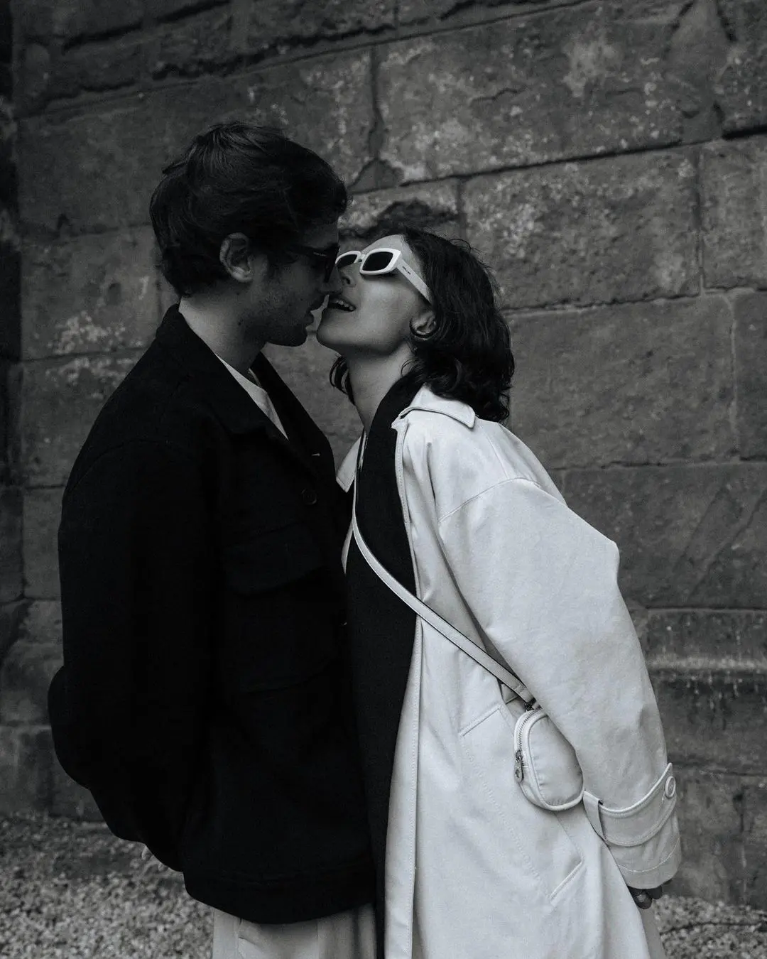 Pareja de novios compartiendo un beso apasionado, ella con gafas de sol, en una celebración íntima del Día de San Valentín.