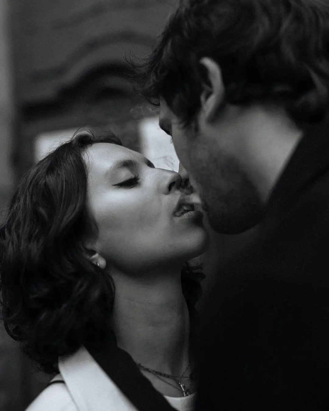 Pareja compartiendo un momento íntimo con humo de tabaco entre sus bocas, simbolizando conexión en el Día de San Valentín.