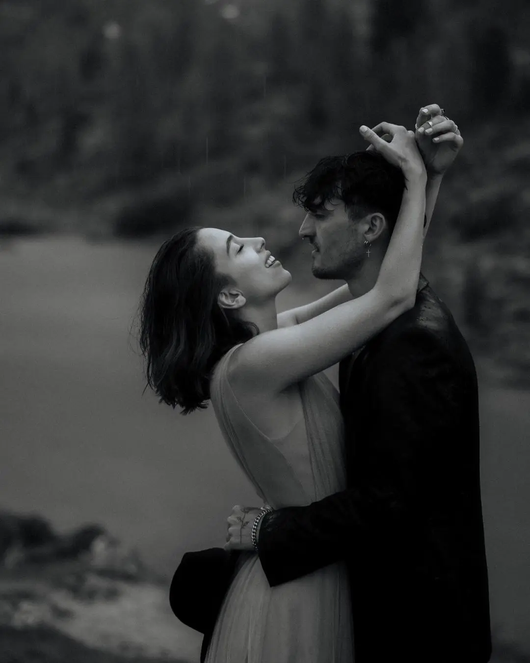 Pareja sonriente en un abrazo íntimo, él la agarra de la cintura y ella de la cabeza, celebrando su amor en San Valentín.