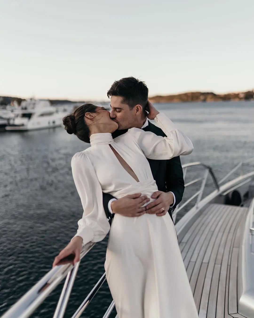 Novios compartiendo un beso en un barco, ejemplificando la unión de amor y tecnología en la organización de bodas digital.