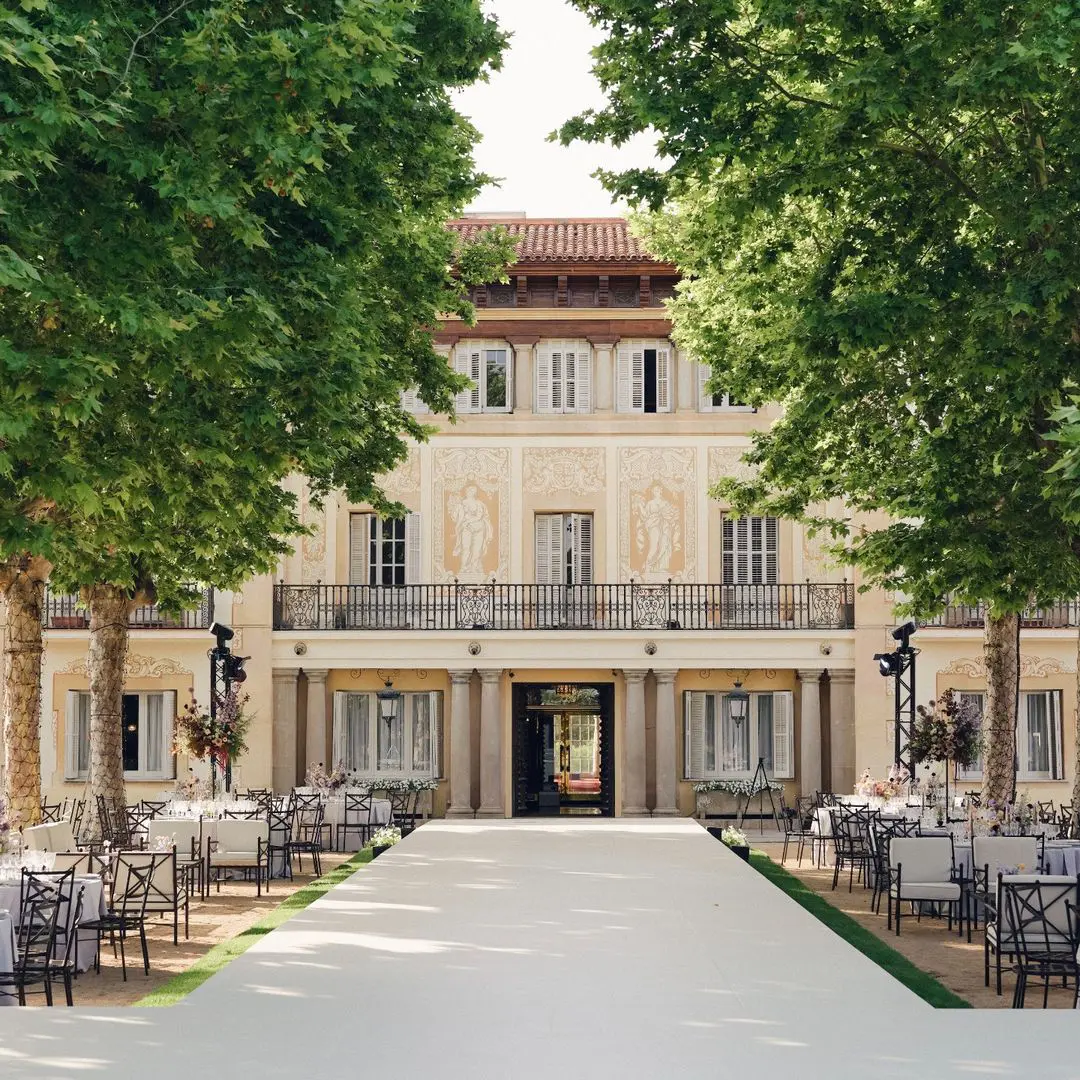 Mesas de boda elegantemente preparadas a los pies de la fachada renacentista de Finca Mas Solers, exudando glamour y tradición.