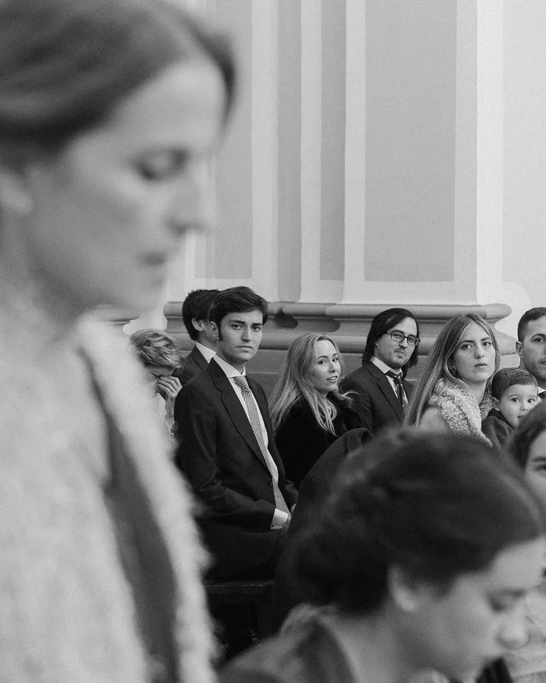 Invitados de boda sentados ordenadamente durante la ceremonia como ejemplo de etiqueta apropiada