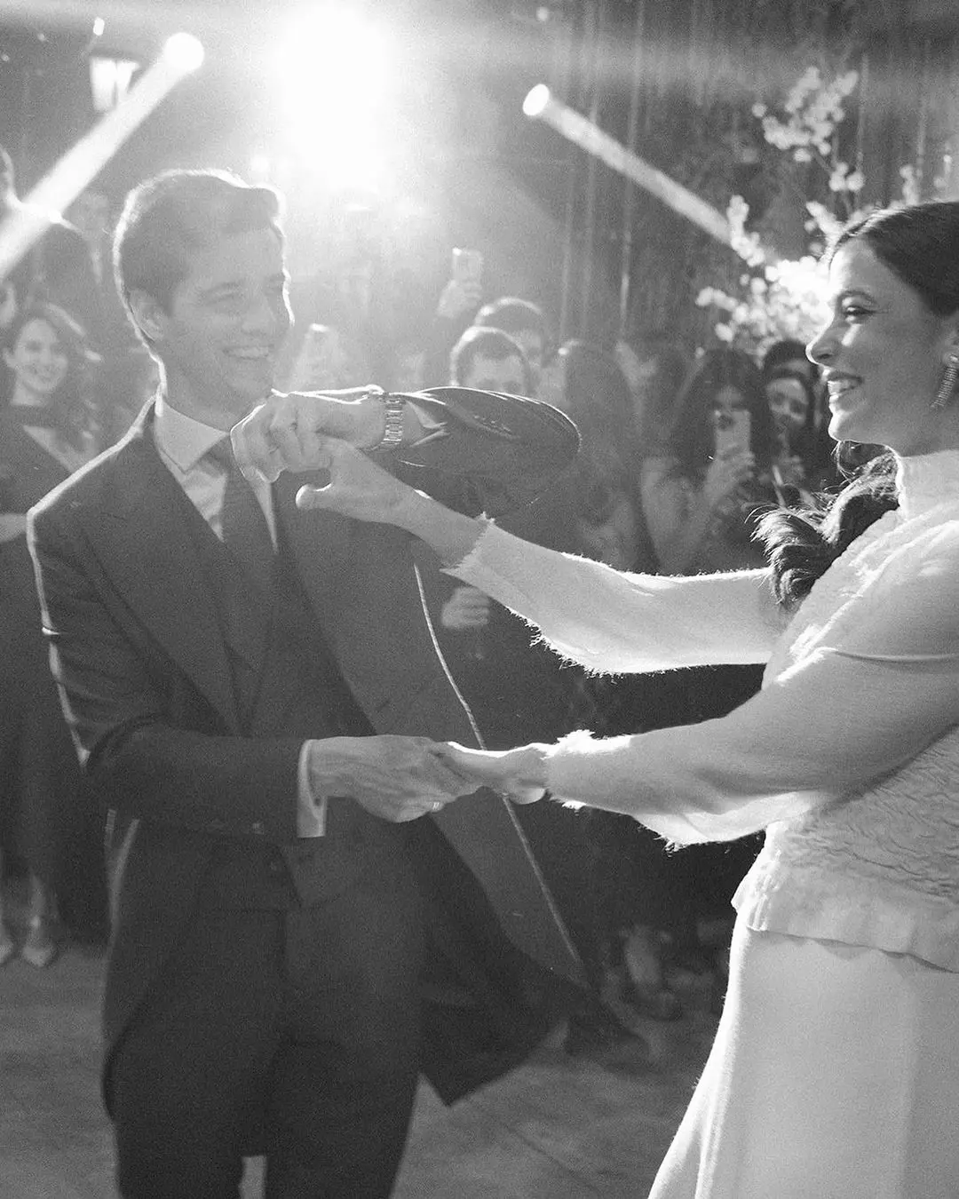 Novios bailando su primer vals con invitados observando en círculo