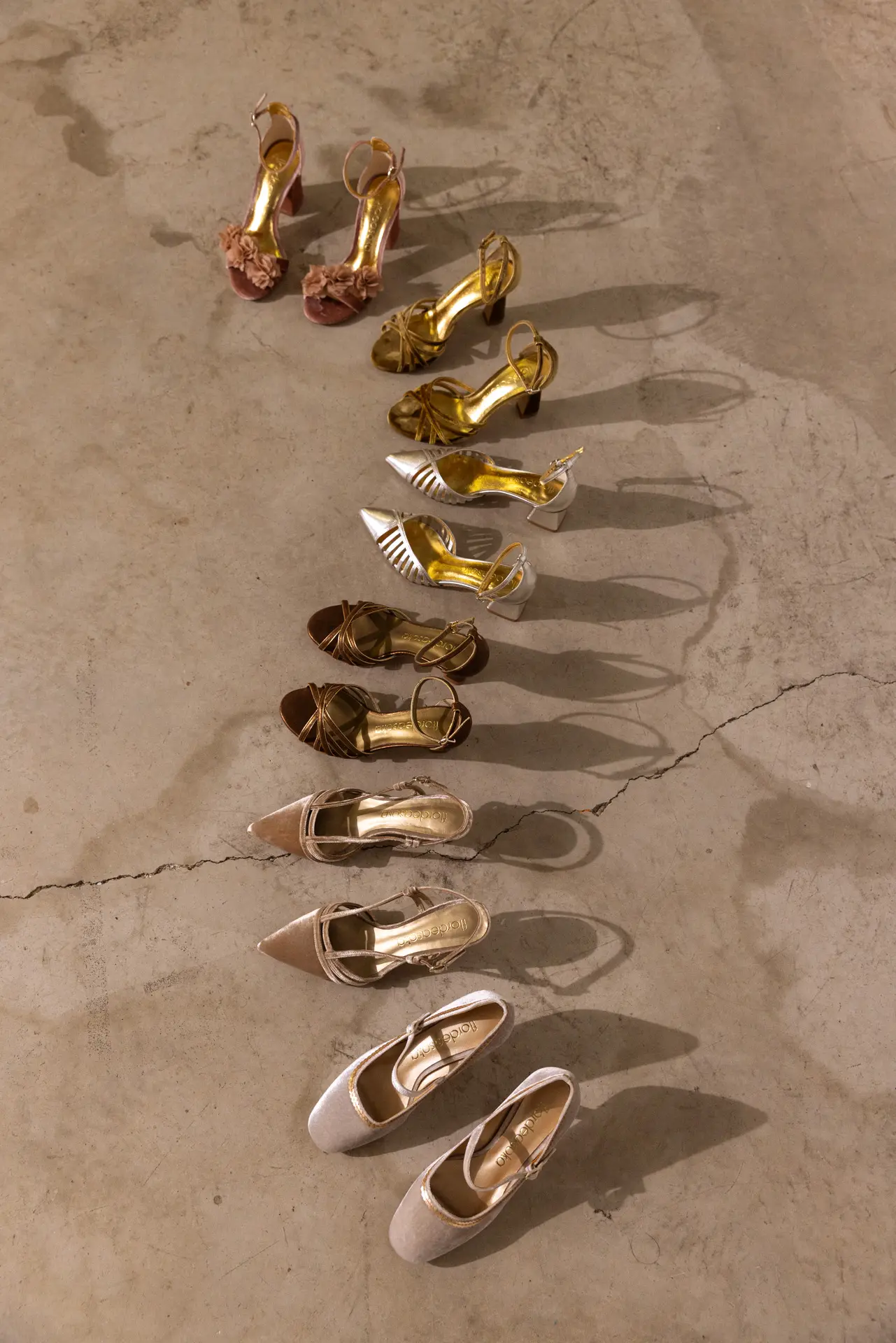 Variedad de zapatos de novia de Flordeasoka dispuestos artísticamente en forma de "S", mostrando la diversidad de estilos y tendencias en calzado nupcial.