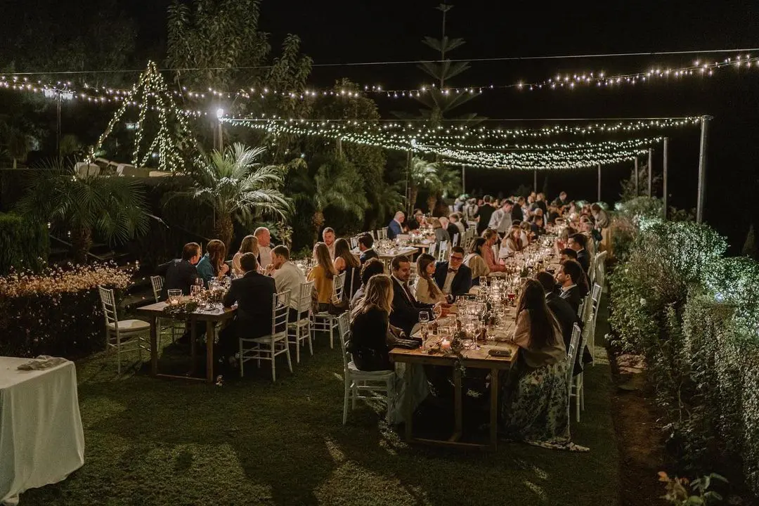 Mesas alargadas iluminadas por bombillas en una boda nocturna en Finca Villa Palma, uno de los mejores lugares para bodas en Marbella.