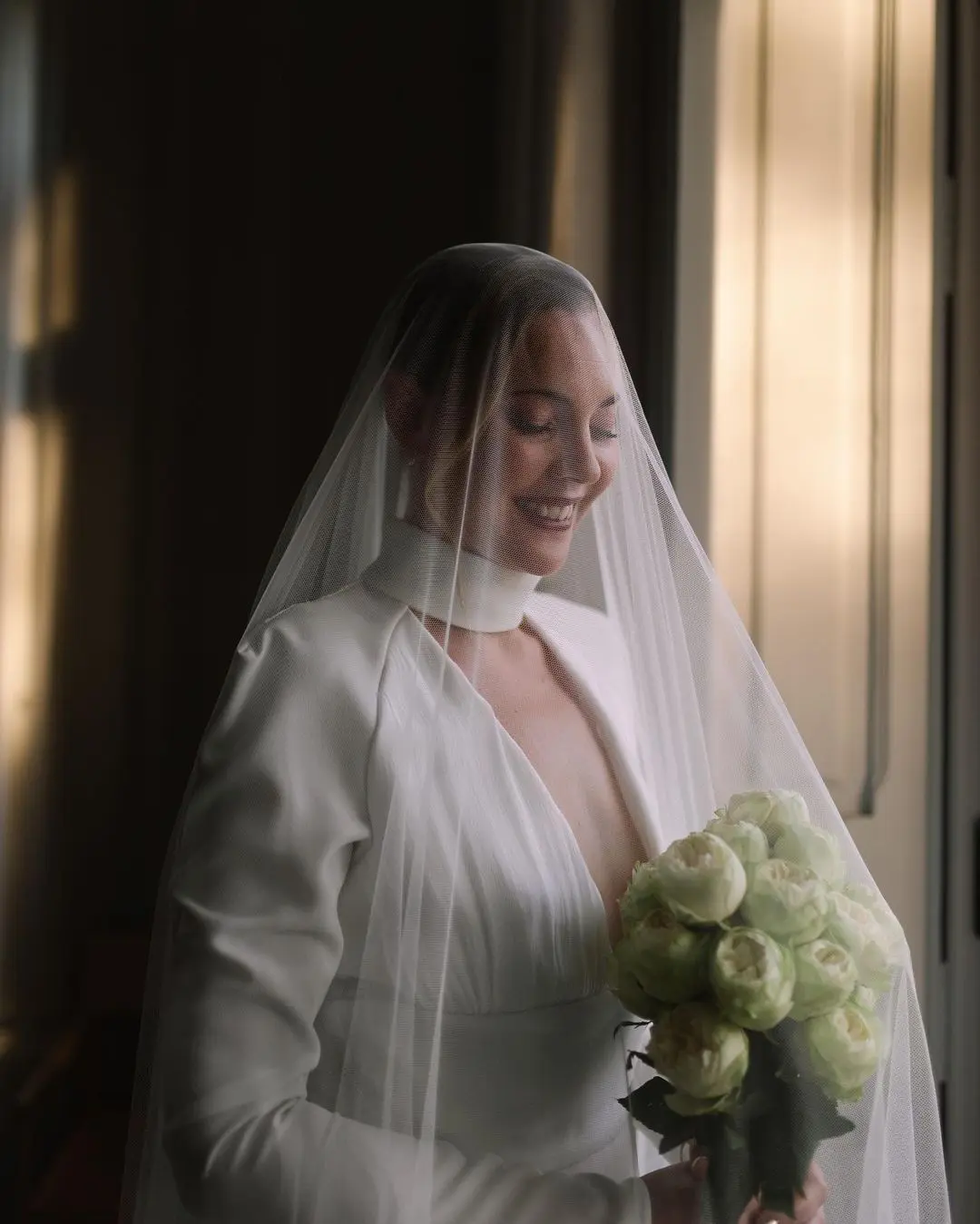 Boda de destino en España con novia sonriendo con velo y ramo