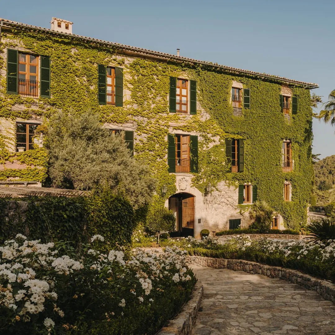 Fachada de Finca Cortesín adornada con enredaderas verdes, destacada como una de las mejores fincas para bodas en Marbella.