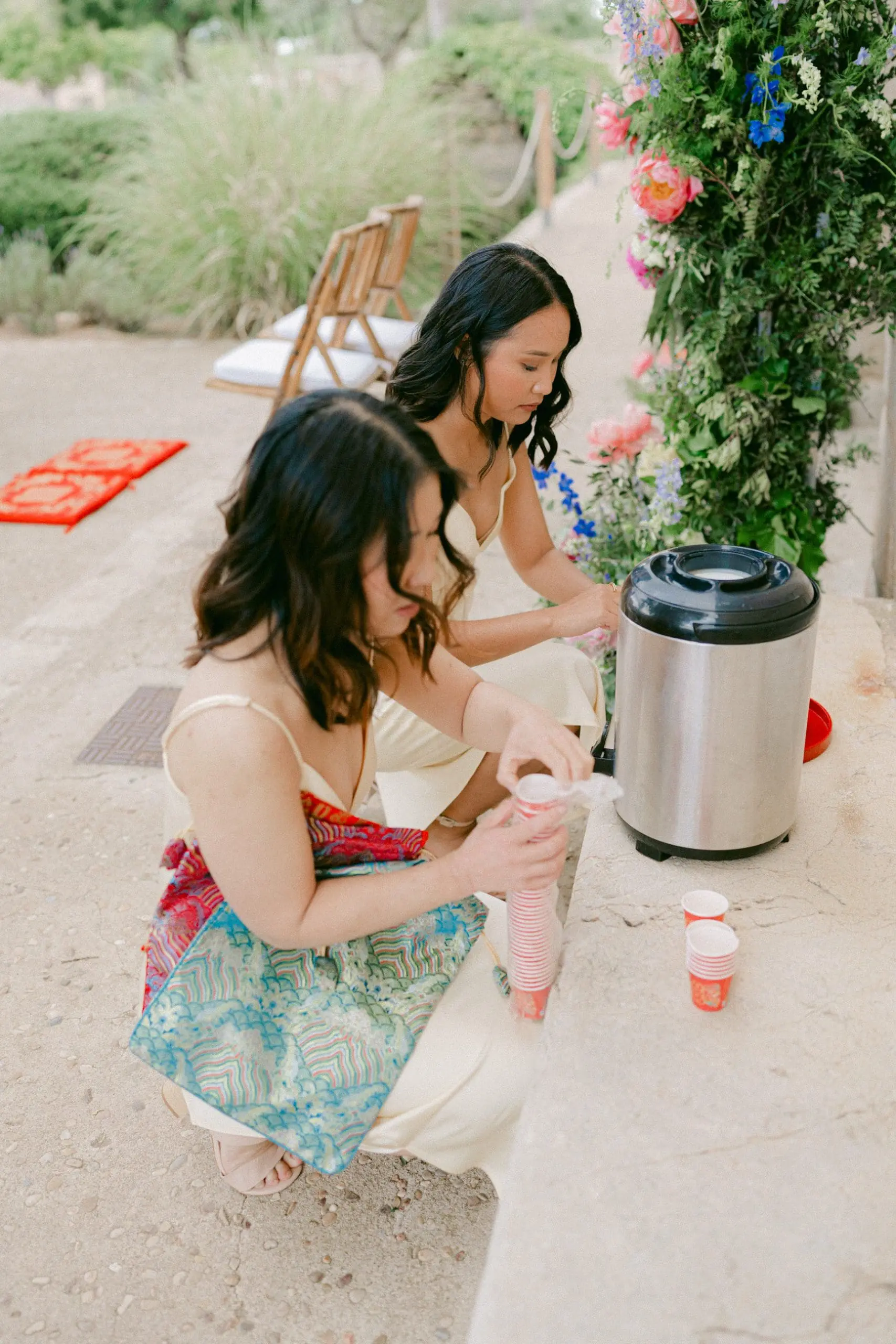 Amigas de la novia preparando té en un termo para los invitados durante la ceremonia del té en una boda china.
