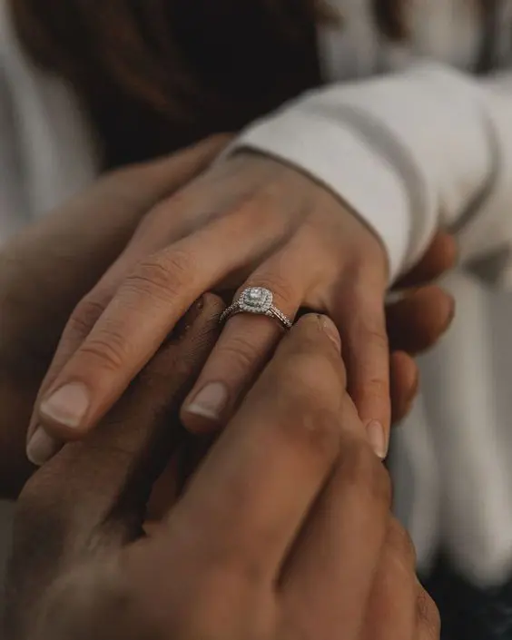 Pedida de mano íntima con anillo de compromiso halo.