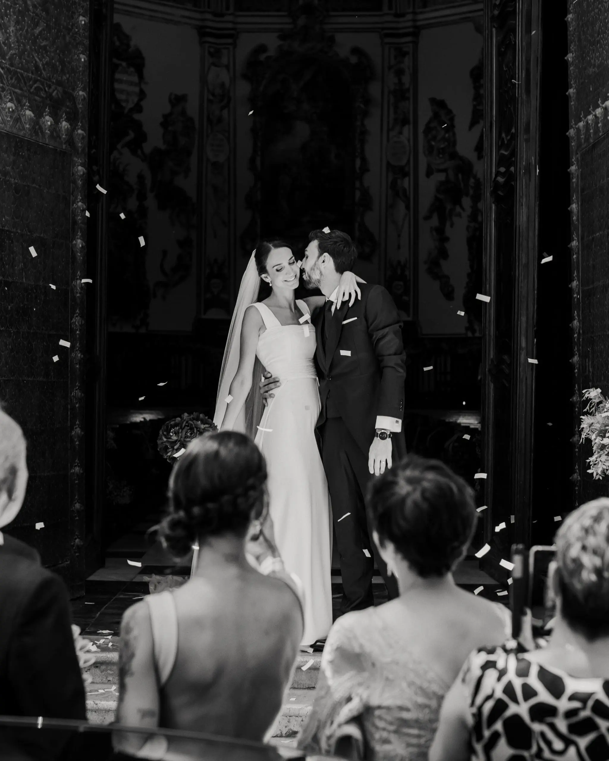 Novios besándose en la salida de la iglesia, mostrando cuánto cuesta una boda según el lugar y los servicios incluidos.