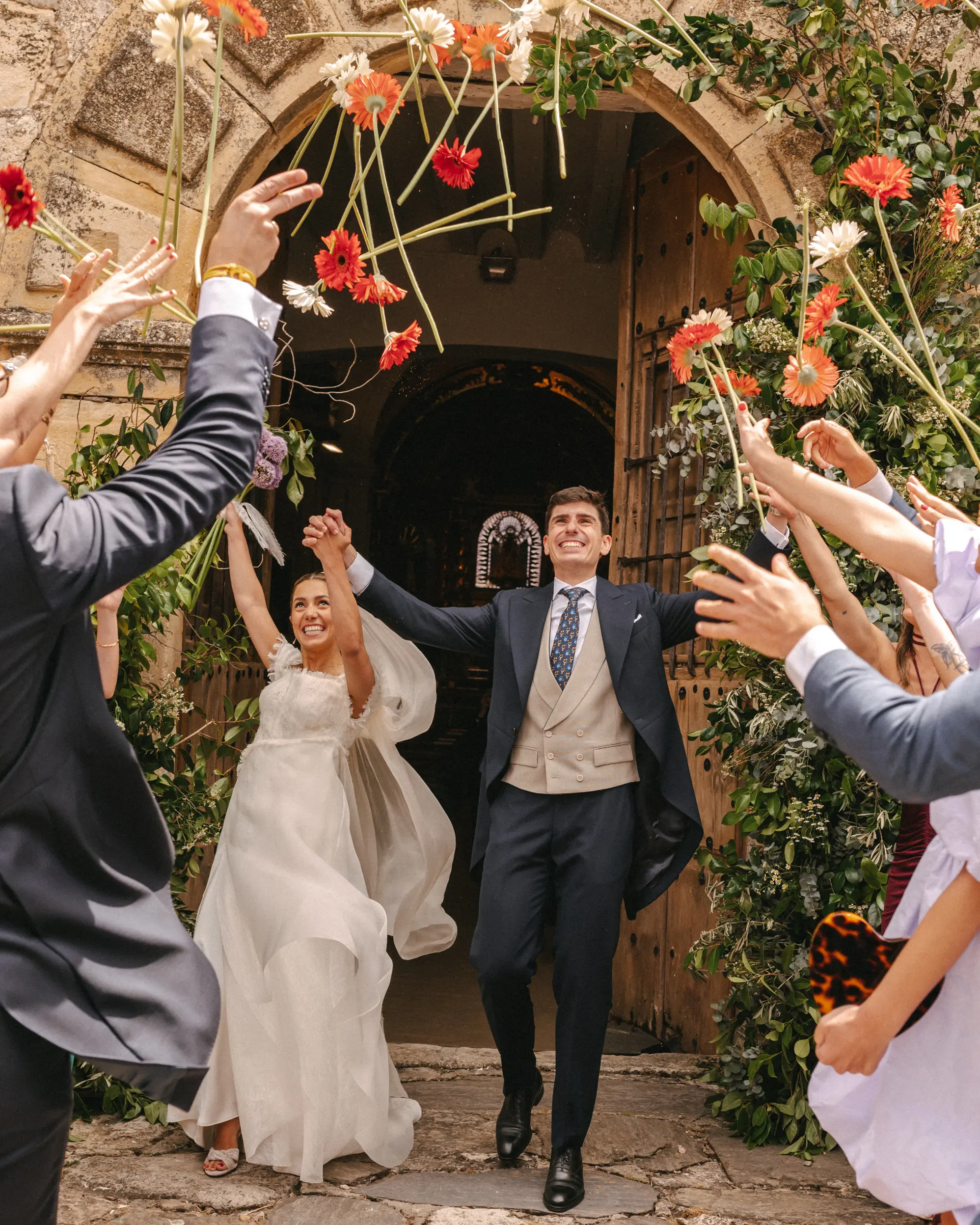 Recién casados celebrando su boda con flores en la salida de la iglesia