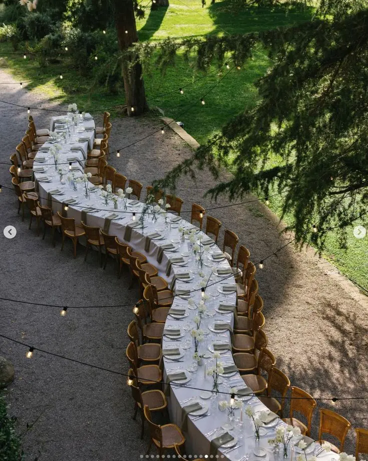 Mesa alargada para muchos invitados dispuesta en forma de S, diseño innovador según las tendencias de boda 2025.
