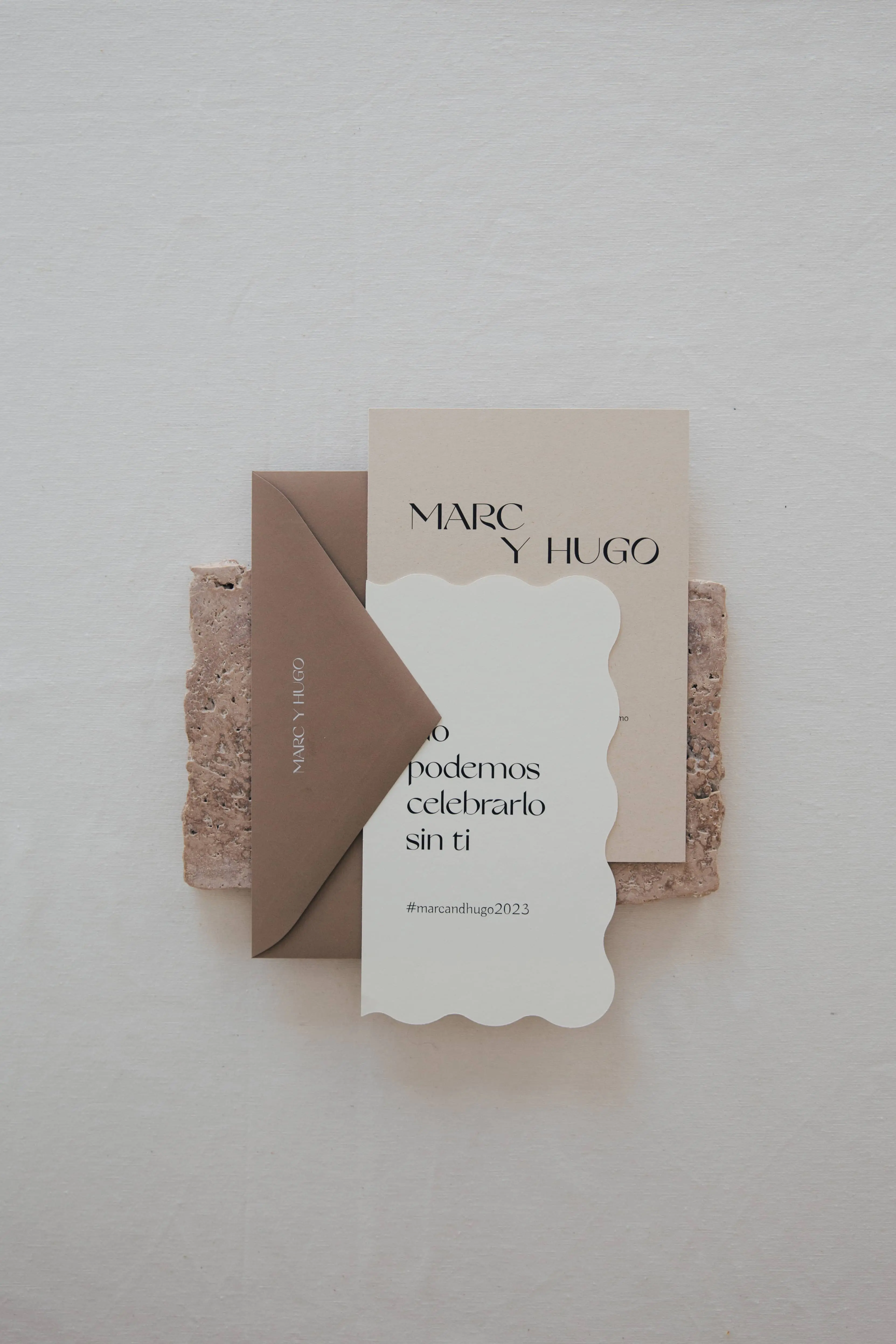 Invitaciones de boda con tipografía moderna en colores cálidos y sobre marrón.