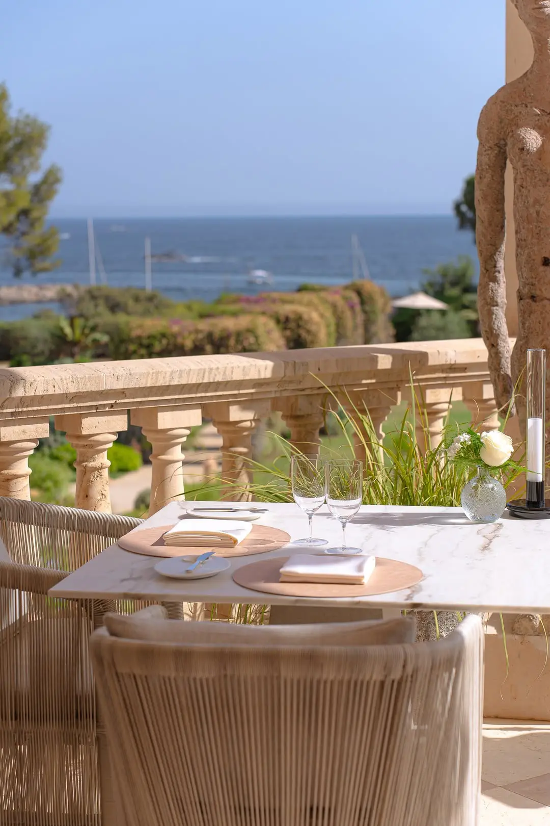 Mesa elegante para dos con vistas al mar en una terraza romántica de Mallorca.