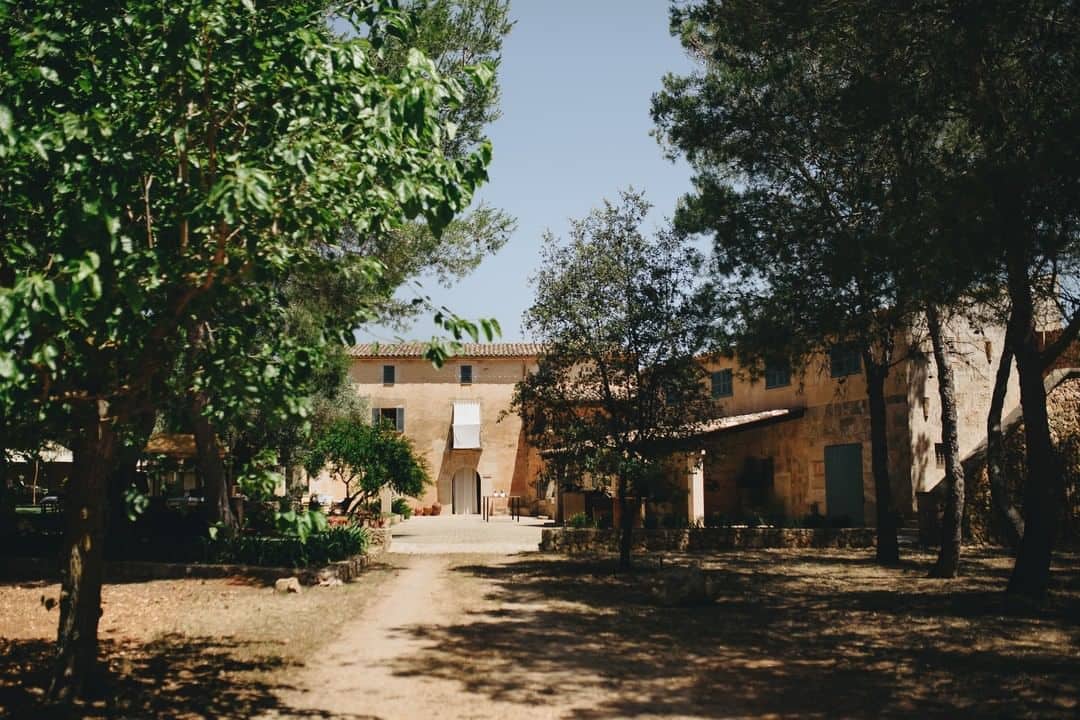 Finca Son Sampol en Mallorca con su fachada elegante rodeada de exuberante vegetación. Esta es una de las mejores fincas para bodas en Mallorca.
