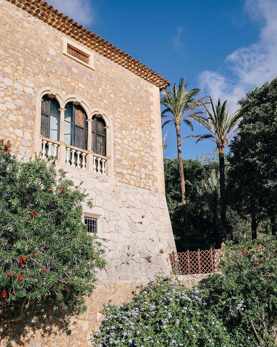 Espléndida fachada de Finca Son Marroig con majestuosas palmeras en el fondo.