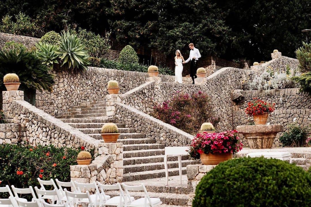 Romántico momento: Novios bajando por una escalera empedrada en Finca Son Berga, Mallorca. Esta es una de las mejores fincas para bodas en Mallorca.