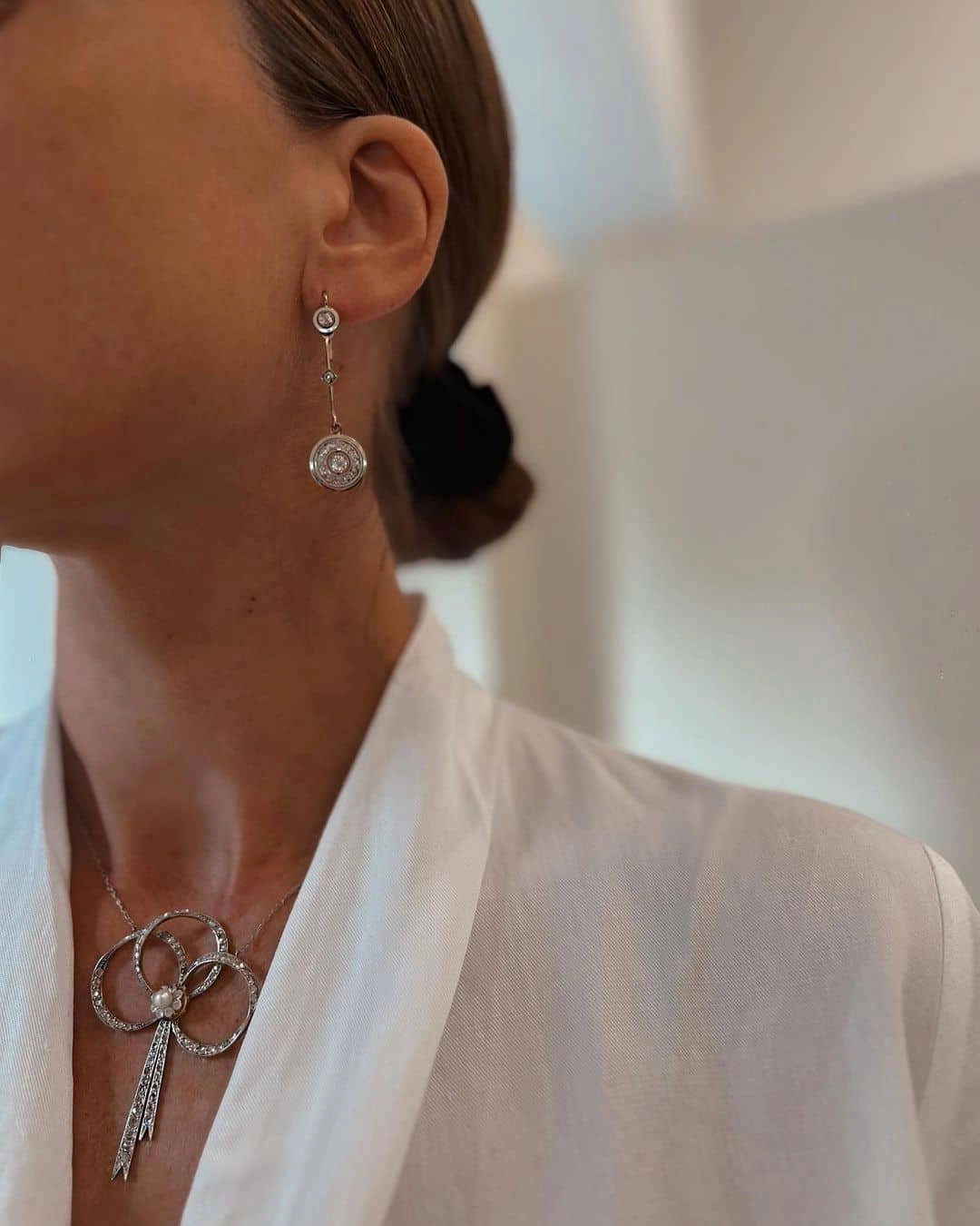 Pendientes largos de novia de la colección Joyas Sardinero brillando en un fondo neutro.