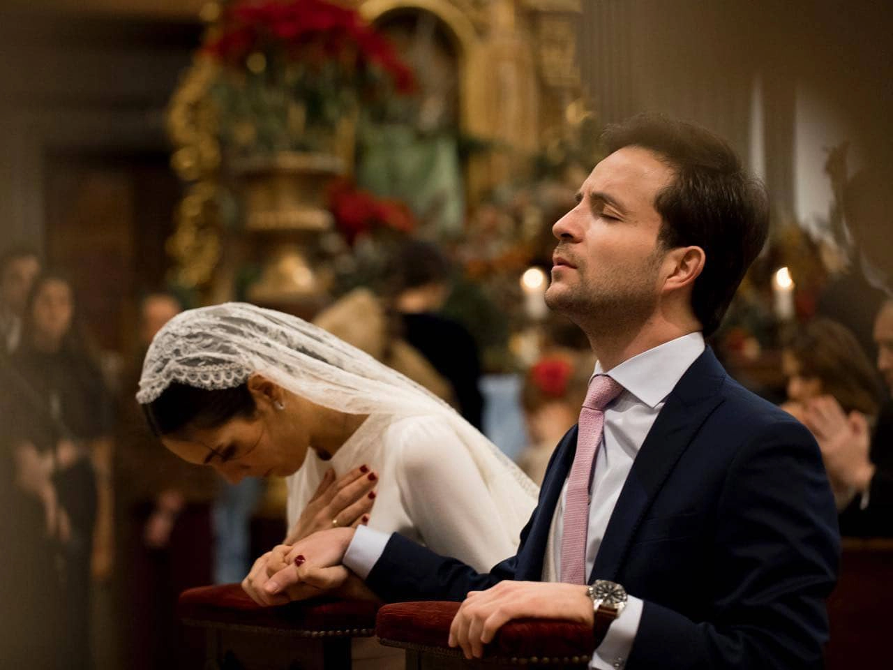 Novios rezando con los ojos cerrados frente al altar en un momento casi místico durante el rito de la velación