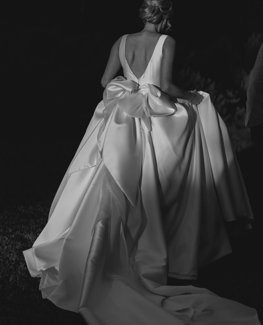 Novia de espaldas caminando hacia el altar, su vestido con espalda descubierta simboliza la elegancia y la modernidad en la organización de bodas digital.