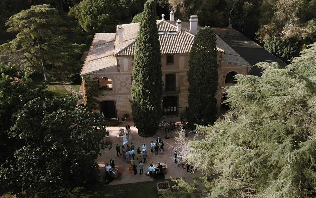 Vista aérea del edificio de La Centenaria 1779 en Barcelona, destacando su arquitectura única y jardines circundantes.