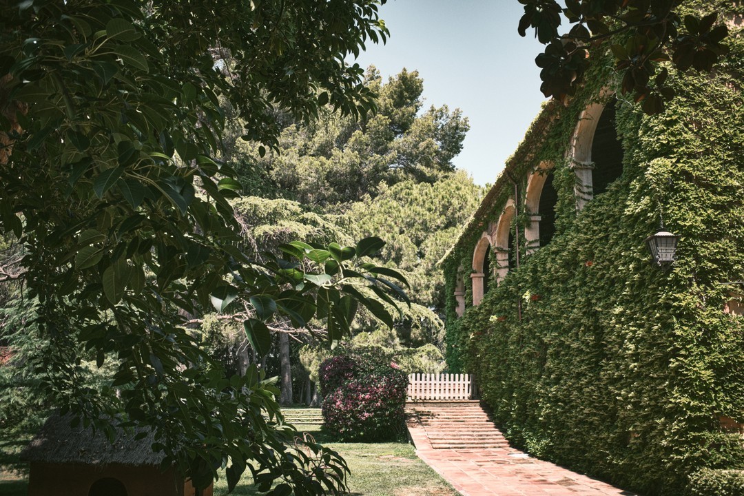 Jardines serenos de La Centenaria 1779 en Barcelona, rodeados de árboles centenarios y una atmósfera de calidez, ideales para bodas al aire libre.