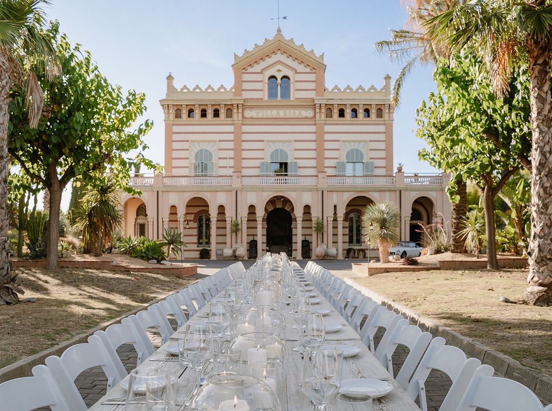 Mesa de boda elegante y alargada con Gran Villa Rosa de fondo, combinando lujo y tradición en Sitges, Barcelona. Es uno de los Mejores Lugares para bodas en Barcelona