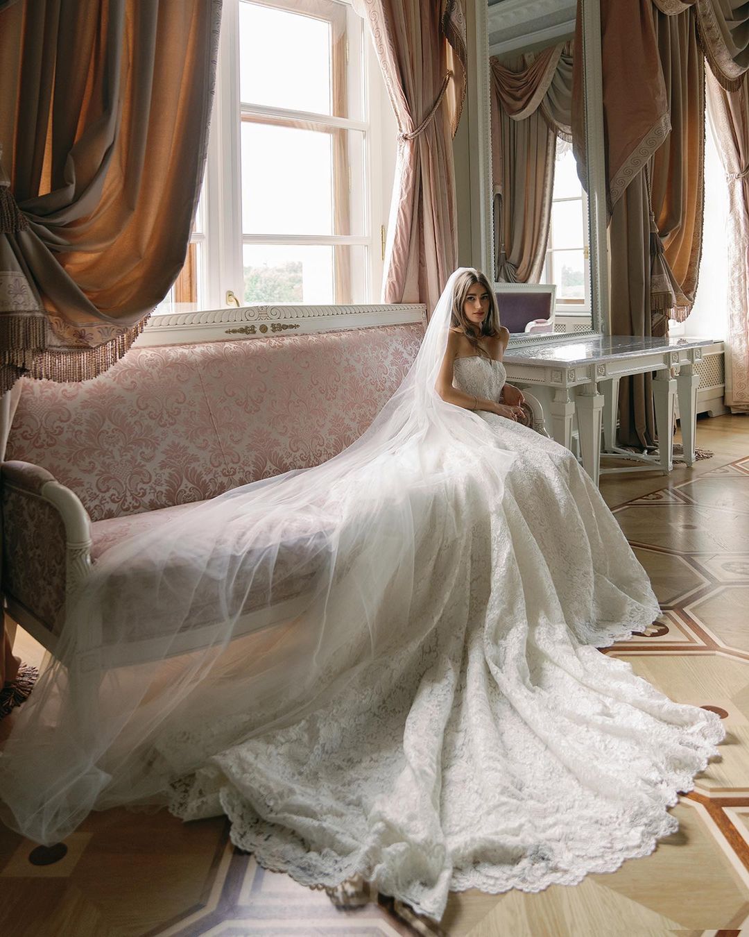 Novia sentada en el sofá con una cola de novia larga, destacando la elegancia y la tradición en una de las mejores fechas para casarse según la astrología en 2025
