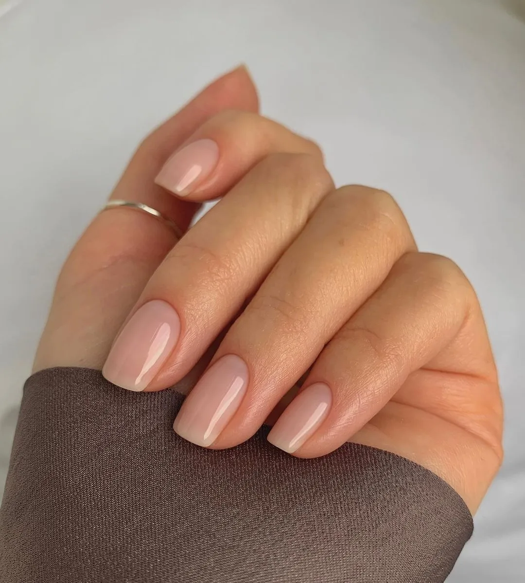 Primer plano de uñas al natural para novia, con un brillo natural y aspecto limpio.