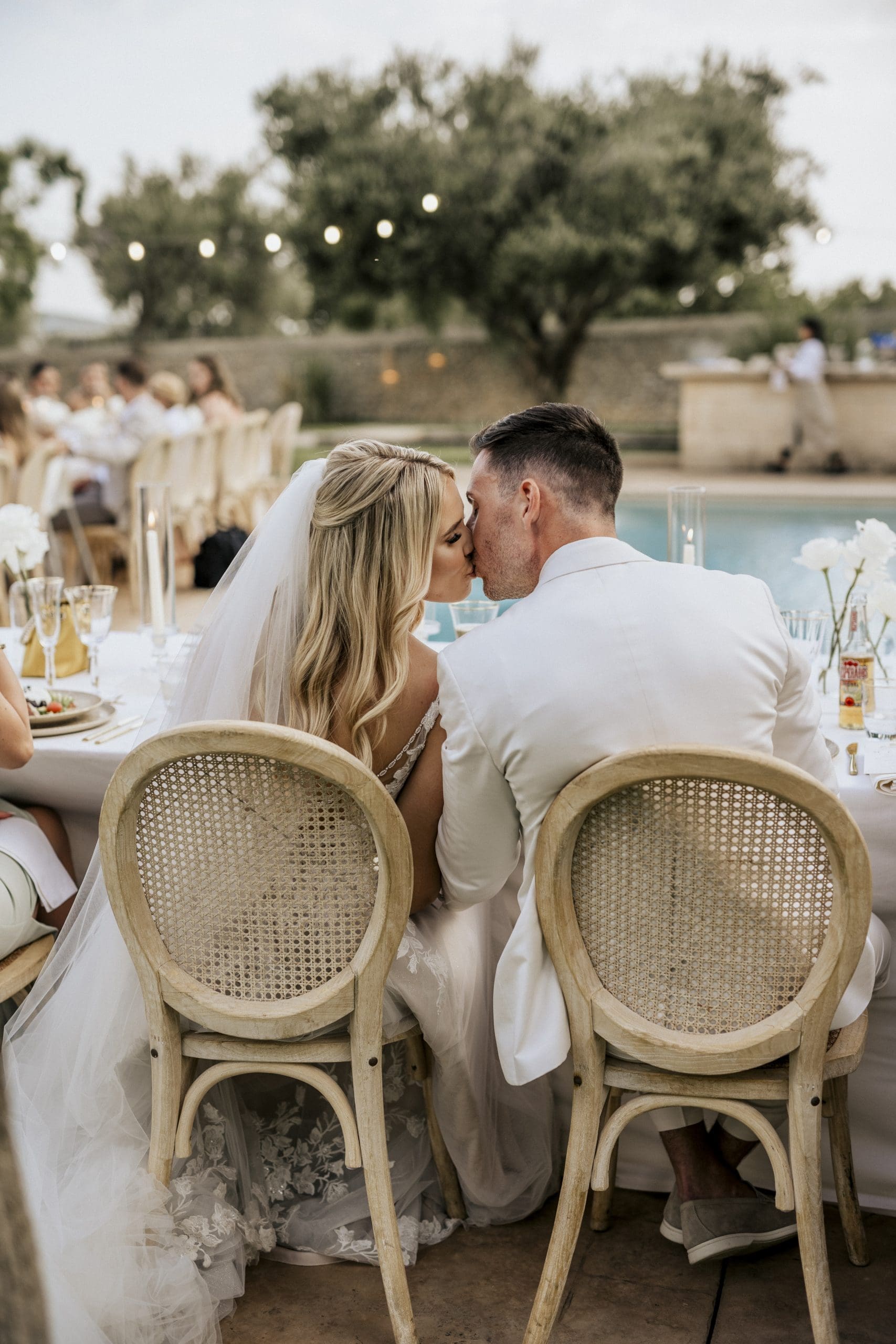 Novios besándose durante el banquete de su boda en una finca de Mallorca, ejemplo de evento planificado en el curso de wedding planner de Bouclé Weddings