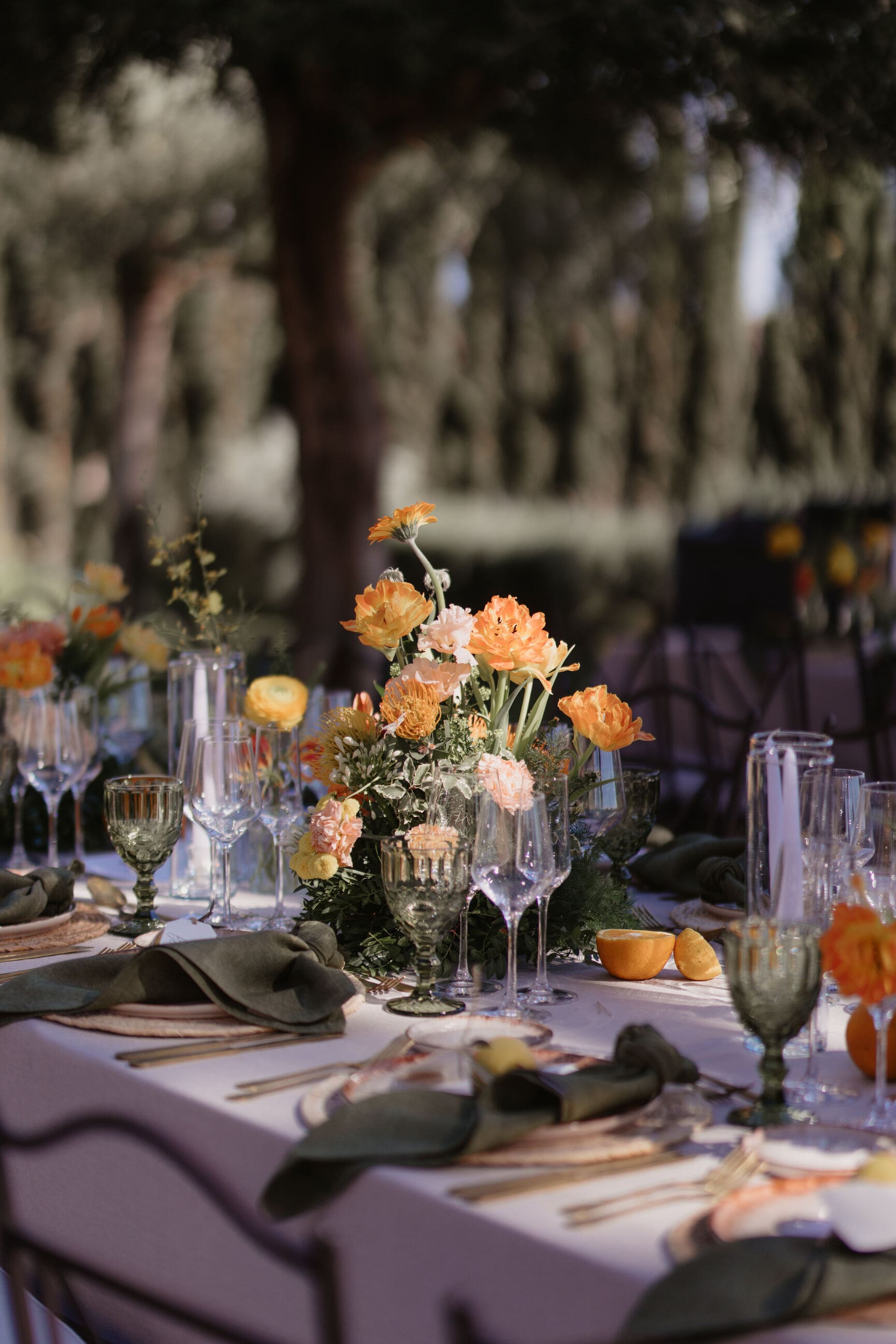 Arreglo floral vibrante en tonos naranjas, amarillos y corales, parte de una decoración de boda organizada por Bouclé Weddings siguiendo las tendencias de boda 2025.