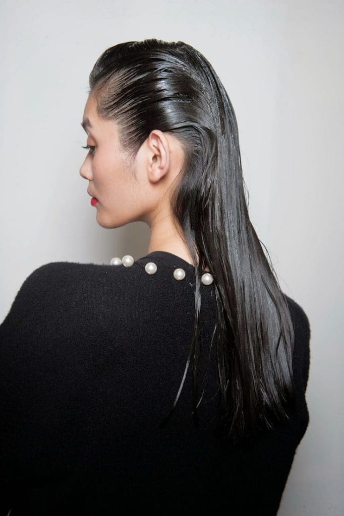 Peinado efecto mojado con cabello hacia atrás, un estilo atrevido para invitadas de boda.