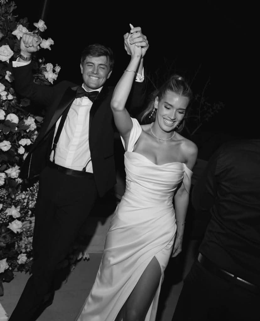 Pareja de recién casados celebrando juntos en una recepción nocturna, irradiando felicidad y estilo.